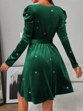 Green velvet puff sleeve dress with starry details and satin waistband