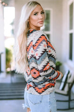 Women’s long sleeve V-neck Southwestern print top with denim shorts