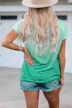 Blonde woman in green round neck pocket tee shirt, denim shorts, beige sun hat