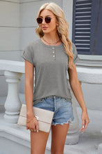 Woman in round neck rolled short sleeve t-shirt with denim shorts and clutch