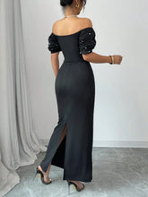 Black satin off-shoulder gown with pearl embellishments and high slit