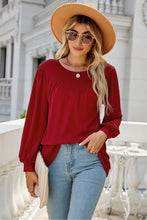 Woman in burgundy long sleeve cotton blend blouse and jeans