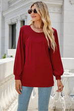 Woman in burgundy long sleeve cotton blend blouse and jeans