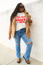 Woman in tan sherpa jacket, distressed jeans, brown loafers wearing Simply Love Chiefs Era short sleeve T-shirt
