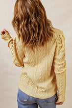 Woman in round neck long sleeve blouse with moderate stretch, yellow cable-knit sweater and jeans