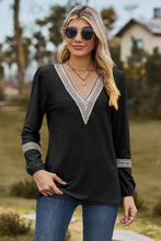 Women’s black long sleeve V-neck top with white embroidered trim