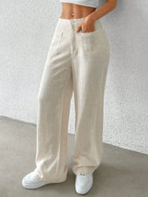 Cream-colored linen wide-leg pants with a relaxed fit and front pockets for comfortable wear