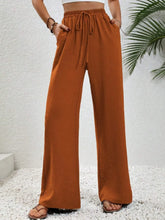Cropped rust-colored wide leg drawstring pants with elastic waistband designed for comfortable casual wear