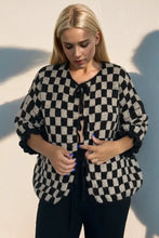 Pink and white checkered blouse with ruffled sleeves and lace-up front