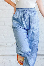 Light blue satin leopard print joggers with elastic waistband machine wash cold and subtle leopard print design