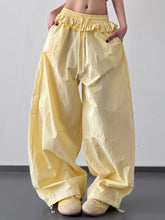 Pale yellow ruffled drawstring wide leg pants featuring a loose and comfortable wide leg silhouette