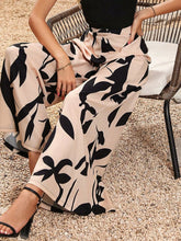 Beige and black printed wide leg pants with leaf pattern and flowing satin-like fabric for stylish comfort