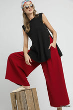 Black sleeveless top with flowing asymmetrical hemline paired with umgee elastic waist wide leg pants with elastic waistband