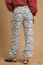 Cream-colored umgee scenic print casual sweatpants with blue forest print elastic cuffs and waistband for comfort