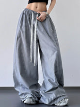 Striped wide leg drawstring pants in navy and white vertical stripes with elastic waistband and lace-trimmed drawstring
