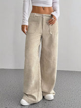 Beige wide leg corduroy pants with a relaxed fit and front pockets made from soft corduroy fabric