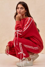 Red velour tracksuit with white striped lined bow details and drawstring ties in bow details fleece design