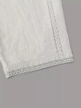 White wide leg cropped pants featuring lace-trimmed fabric with delicate patterns along the hem and side seam