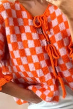 Orange and white checkered knit sweater with tassels and ruffles