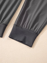 Dark gray smooth fabric jogger pants with elastic high waist and elasticated cuffs in high waist pocketed style