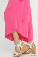 White strappy wedge sandals with natural cork sole and silver buckle paired with flowy asymmetrical hem wide leg pants
