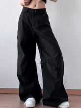Black wide leg oversized pants with a high waisted relaxed fit and subtle front pleats including care instructions