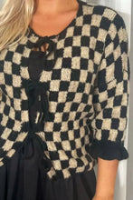 Pink and white checkered blouse with ruffled sleeves and lace-up front