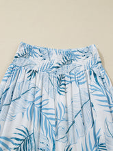 White tropical print shirred waistband wide leg pants featuring blue leaf pattern and elastic waistband