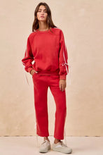 Red sweatshirt with white striped sleeves and drawstring cuffs paired with BiBi side lined bow details fleece sweatpants