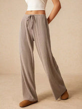 Beige corduroy wide leg pants with a drawstring waist for comfortable casual wear