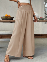 Beige smocked waist wide leg pants with elastic waistband and two front patch pockets for comfortable wear