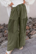 Olive green corduroy tiered wide leg pants featuring tiered panels and a drawstring waistband for comfort