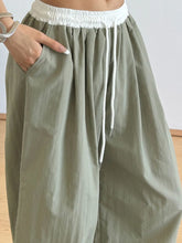 Olive green wide leg drawstring casual pants with white elastic waistband and matching drawstring for comfort wear