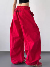 Vibrant red drawstring wide leg pants with elastic waistband and black embroidered text on the back side
