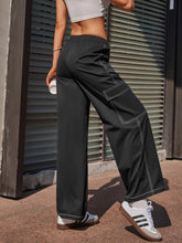 Black wide leg pants with contrast white stitching and side cargo pockets for a stylish casual look