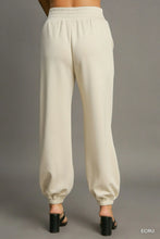 Cream-colored soft fabric umgee drawstring jogger pants with elastic waistband front seam detail and tapered cuffs
