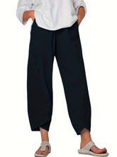 Black elastic waist pants with wide-leg relaxed silhouette and asymmetrical hemline featuring pockets