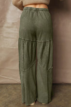 Olive green tiered wide leg pants with relaxed fit and distressed layered patchwork design in cotton fabric