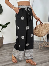 Black wide leg pants with white geometric embroidery and matching patterned waistband boho print wide leg pants
