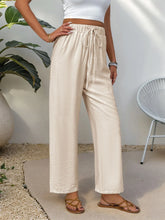 Cream-colored drawstring wide leg pants with a loose fit made from machine wash cold fabric for comfortable wear