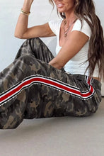 Camo print drawstring waist joggers with wide-leg cut and red white black striped trim along the side seam