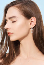 Woman in 1.8 carat moissanite sterling silver drop earrings with pearl