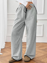 Wide-leg gray heathered sweatpants with black drawstring and zigzag trim, machine wash care instructions included