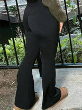 Black high-waisted flare pants made of smooth, form-fitting fabric with a flattering flare silhouette