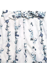 White wide leg pants with a delicate blue floral print tie and matching bow at the waist