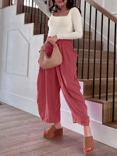 Beige woven straw handbag with soft rounded shape and texture paired with full size wide leg pants with pockets plus size