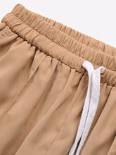 Tan wide leg drawstring casual pants featuring a drawstring waistband with white fabric ties for comfort