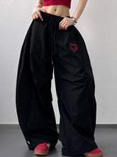 Black heart wide leg casual pants featuring a red embroidered heart on the thigh for stylish leg casual wear