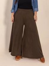 Plus size wide leg brown trousers with smooth flowing fabric and subtle front pleats featuring pockets