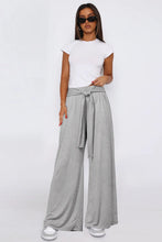 Gray tied pocketed wide leg pants featuring a wide leg fit and a tied waistband for a comfortable style